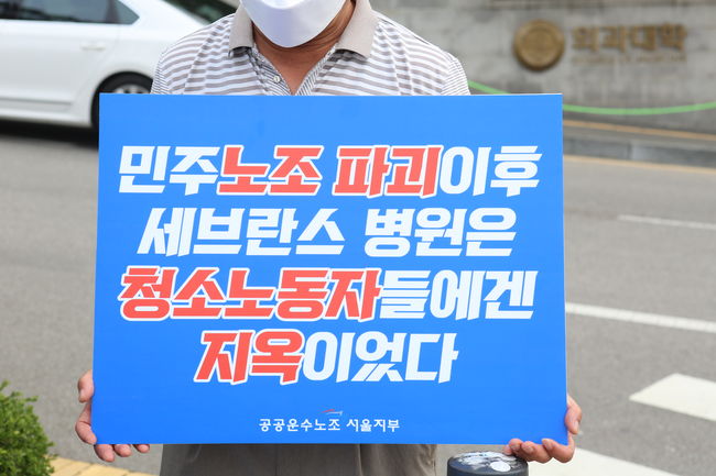 ▲ 세브란스병원 청소노동자가 병원의 노동자 탄압을 고발하는 피켓을 들고 있다.