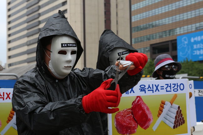 ▲ 채식단체 관계자가 담배와 소시지를 가위로 자르는 퍼포먼스를 선보이고 있다.