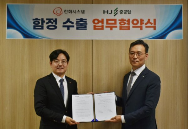 조명섭(왼쪽) 한화시스템 해양사업부장과 이정욱 HJ중공업 특수선영업팀장이 업무 협약을 체결하고 기념촬영하고 있다. 사진=한화시스템